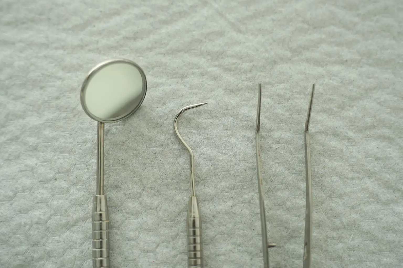 A dental mouth mirror and periodontal probe laid out, the instruments of periodontal screening
